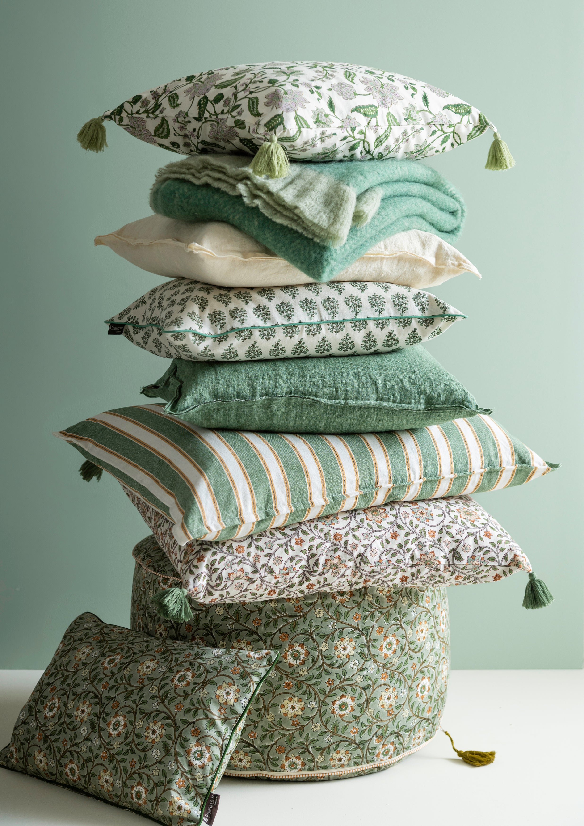 Stack of various patterned pillows on a light gray background