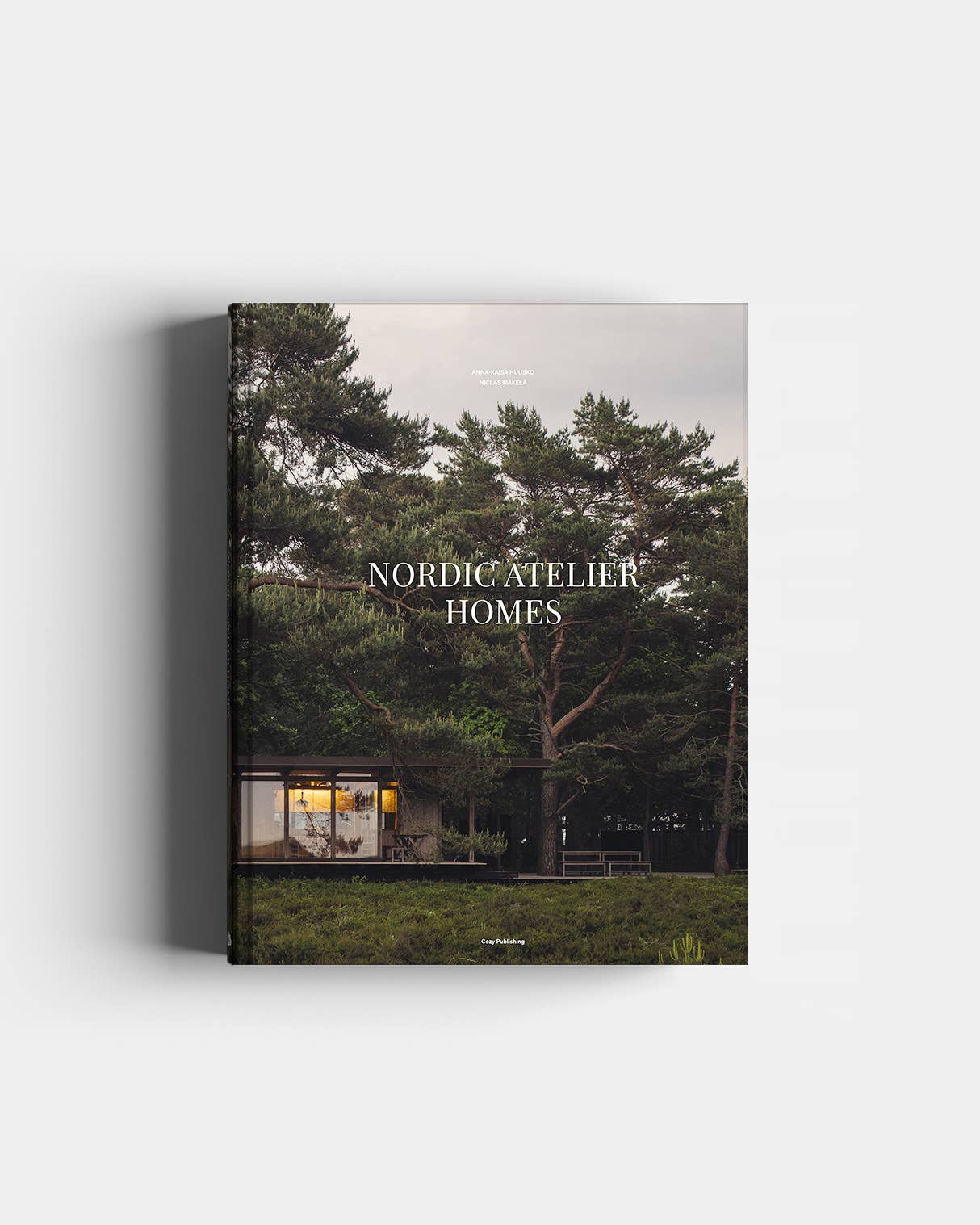 Book titled 'Nordic Atelier Homes' with a cover featuring a house surrounded by trees.