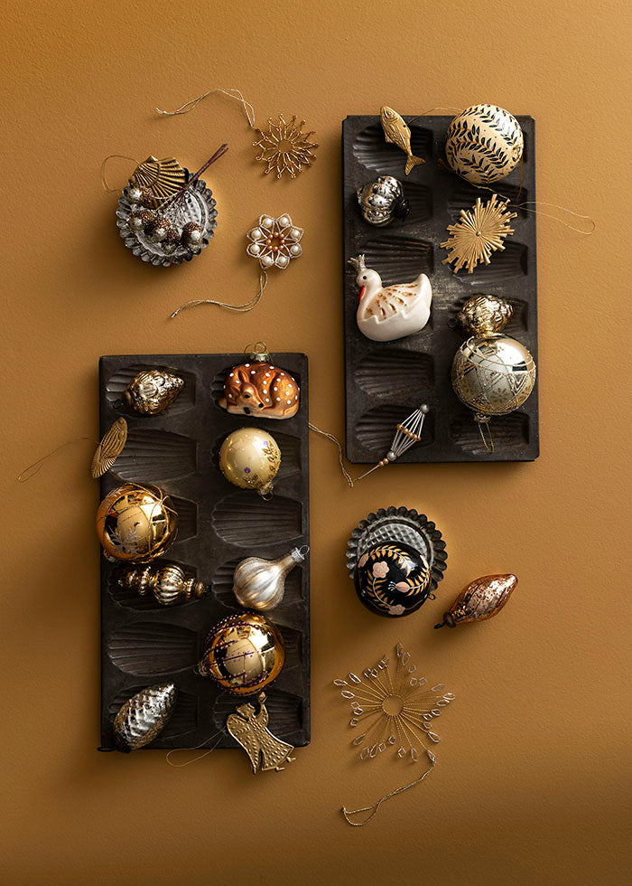 Decorative brass ornaments on black trays against a brown background