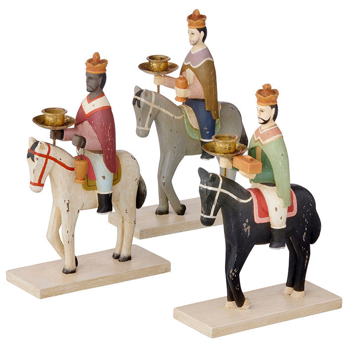Three figurines of kings on horseback with gold trays, set against a white background.