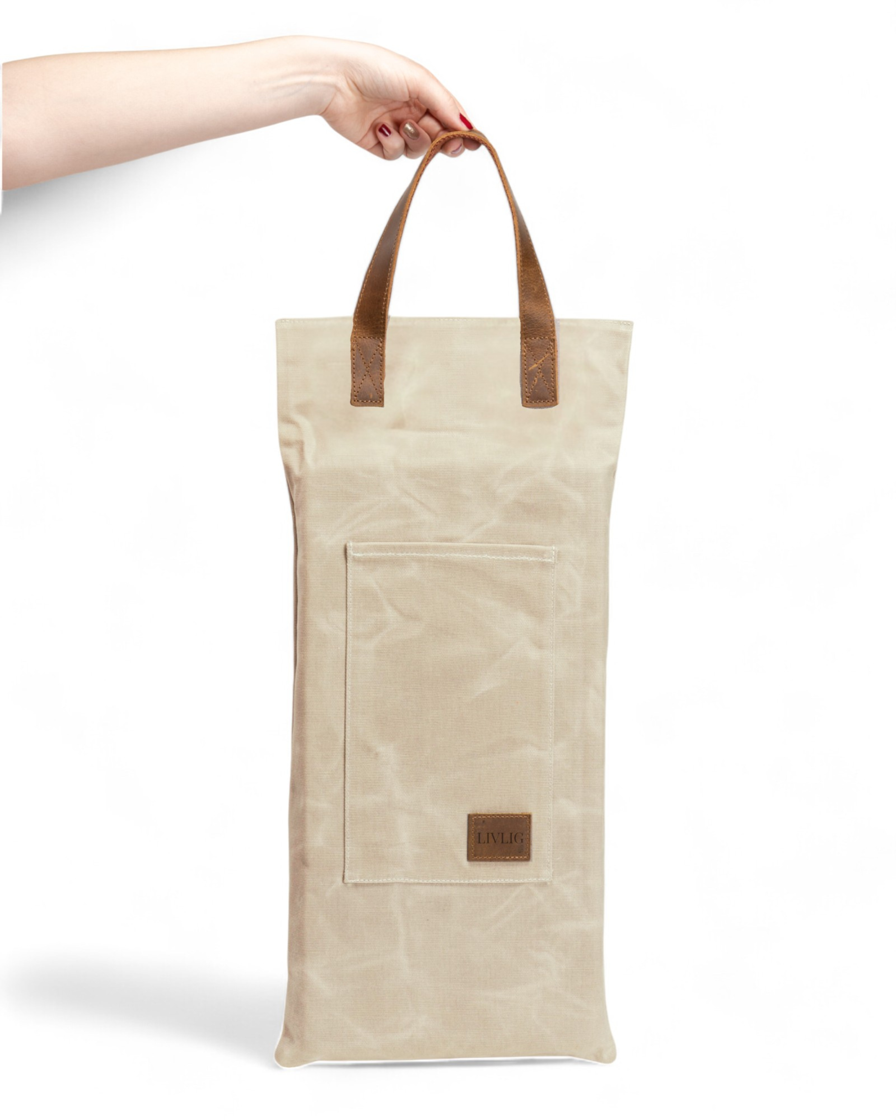 Beige waxed cushion with brown handles held by a hand on a white background