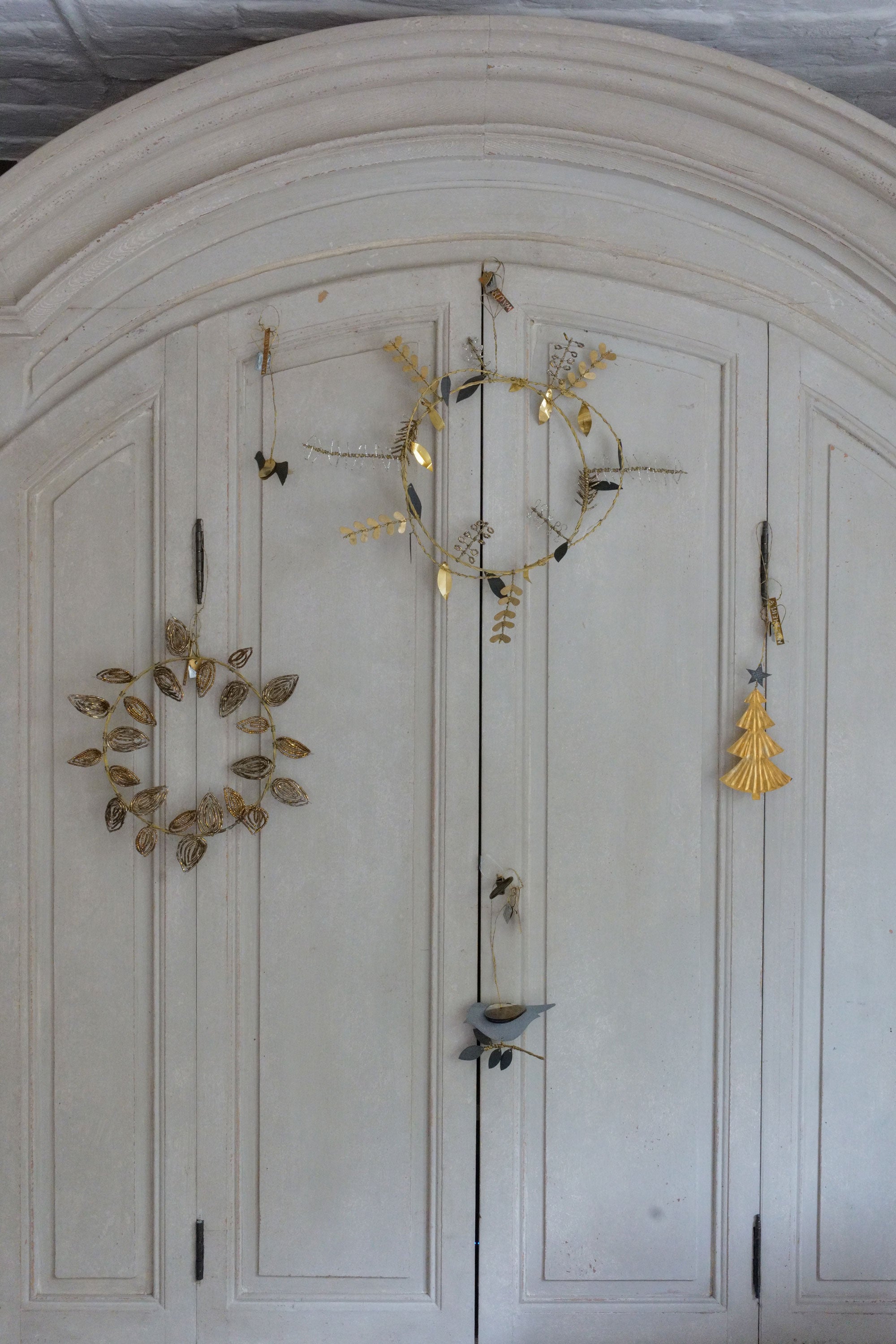 Decorative wall art with gold leaf patterns on a white wall.